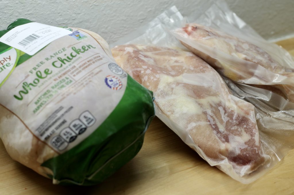  Whole Chicken next to bags of cut up chicken