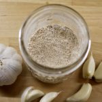 Homemade Garlic Powder surrounded by garlic cloves