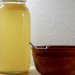 Can of Chicken Broth next to a red bowl