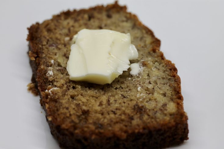 slice of Sourdough Discard Banana Bread with butter on top