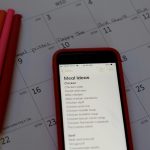Meal Plan Once a Month calendar, pens, and list of meal ideas on a phone