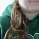 Green hoodie on a woman with a brown pony tail