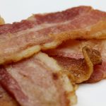 Pile of bacon on white plate