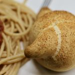 Sourdough Discard Garlic Knots next to spaghetti