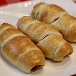 3 Sourdough Pretzel Dogs on a plate on a picnic table