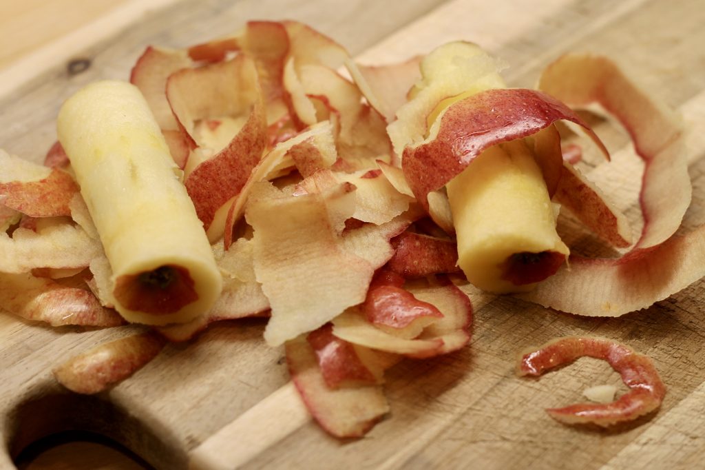 apple peels and a core on a cutting board