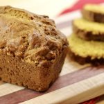 loaf of Sourdough Pumpkin Bread next to three slices of sourdough pumpkin bread